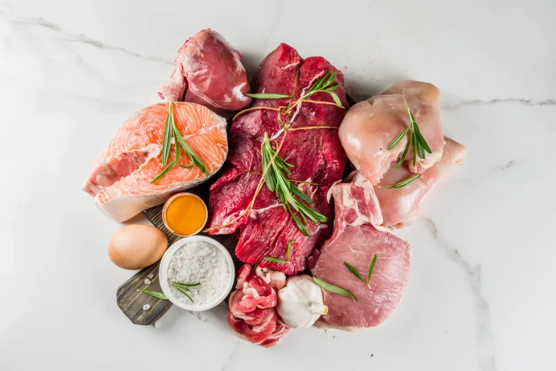 Vibrant assortment of meats on marble, featuring salmon, beef, and pork for culinary inspiration.