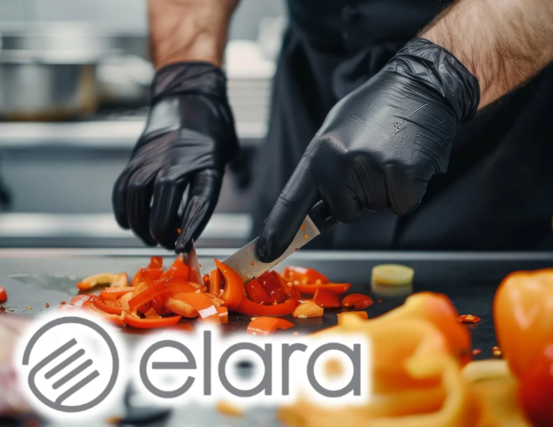 Chef in black gloves dicing fresh red bell peppers on a commercial kitchen prep station for food service.