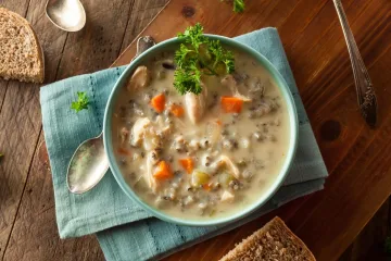 Bowl of creamy chicken and wild rice soup with carrots and parsley for foodservice menus and wholesale food supply.