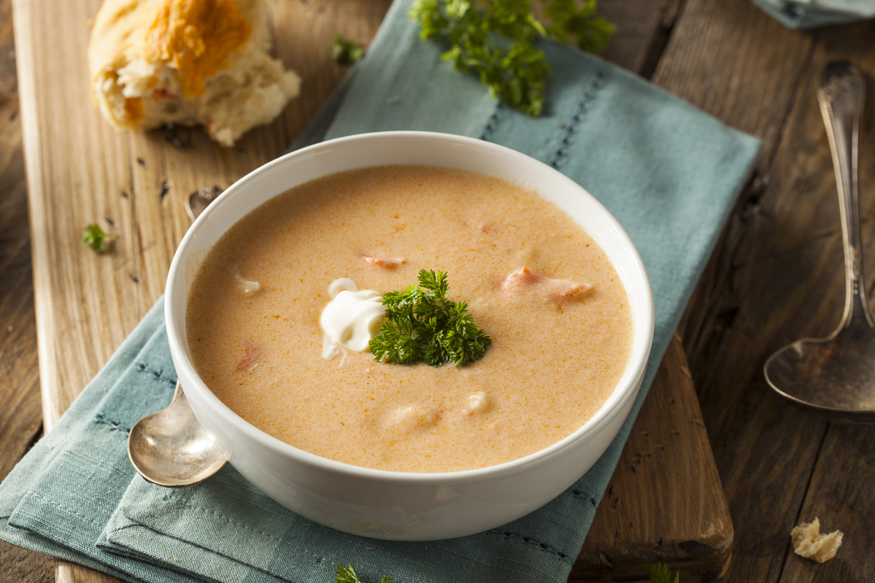 Homemade Lobster Bisque Soup With A Roll And Garnish