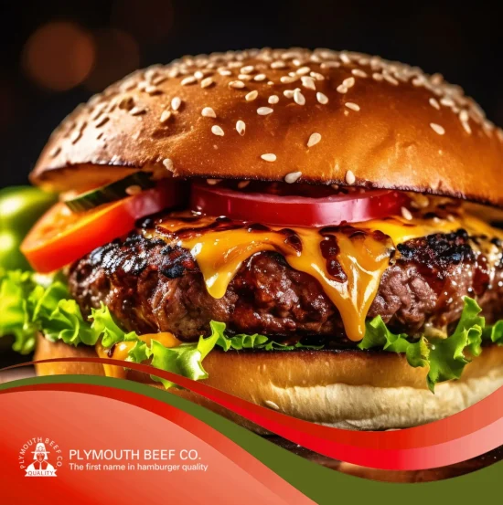A gourmet beef burger patty topped with melted cheddar cheese, tomato, and lettuce on a sesame seed bun from Plymouth Beef Co., a leading foodservice supplier.